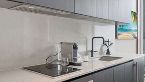 A modern kitchen with a built-in stove, a coffee maker, and a sink. - Luxury 26th Floor Studio E11EVEN w/ Rooftop Pool (Miami)
