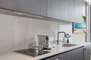 Eine moderne Küche mit eingebautem Herd, einer Kaffeemaschine und einem Spülbecken.