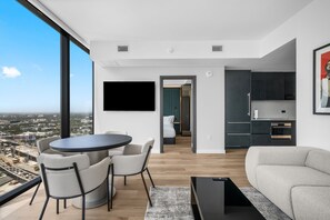 A modern living room with a dining area, a kitchen, and a bedroom. - 35th Floor E11EVEN Retreat with Skyline & Bay Views (Miami)