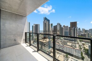 A balcony with a cityscape view, featuring modern high-rise buildings and a clear sky. - 35th Floor E11EVEN Retreat with Skyline & Bay Views (Miami)