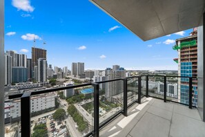 Ein Balkon mit Blick auf die Stadt, darunter Hochhäuser und eine Baustelle.
