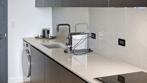 Una cucina moderna con lavastoviglie integrata, lavello in acciaio inossidabile e un piano di lavoro elegante.