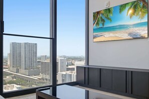 A room with a large window overlooking a cityscape, a painting of a beach scene, and a modern interior design. - E11EVEN 25th Floor Residence w/ Skyline Views (Miami)