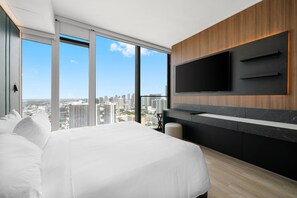 A modern hotel room with a large bed, a TV mounted on the wall, and a city view. - 40th Floor E11EVEN Studio w/ Skyline Views (Miami)
