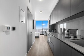 Eine moderne Küche mit Blick auf die Stadt, inklusive Backofen und Kaffeemaschine.
