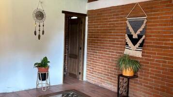 Un banco de madera en una habitación con pared de ladrillo y techo a la vista.