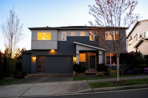 A modern two-story house with a garage, a visible number '3002' on the door, and a well-maintained front yard with a small tree and shrubs. - Restful Bana Resort (Marysville)