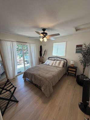 A bedroom with a bed, a ceiling fan, a window, and a nightstand. - Updated Lakefront Home in quiet cove makes the perfect swimming spot with a dock (Sunrise Beach)