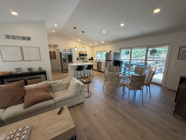 A spacious living area with a sofa, a coffee table, and a dining table with chairs. - Updated Lakefront Home in quiet cove makes the perfect swimming spot with a dock (Sunrise Beach)