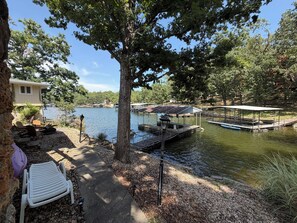 Une propriété située au bord d’un lac, dotée d’un quai, d’un espace salon couvert et d’une chaise longue.