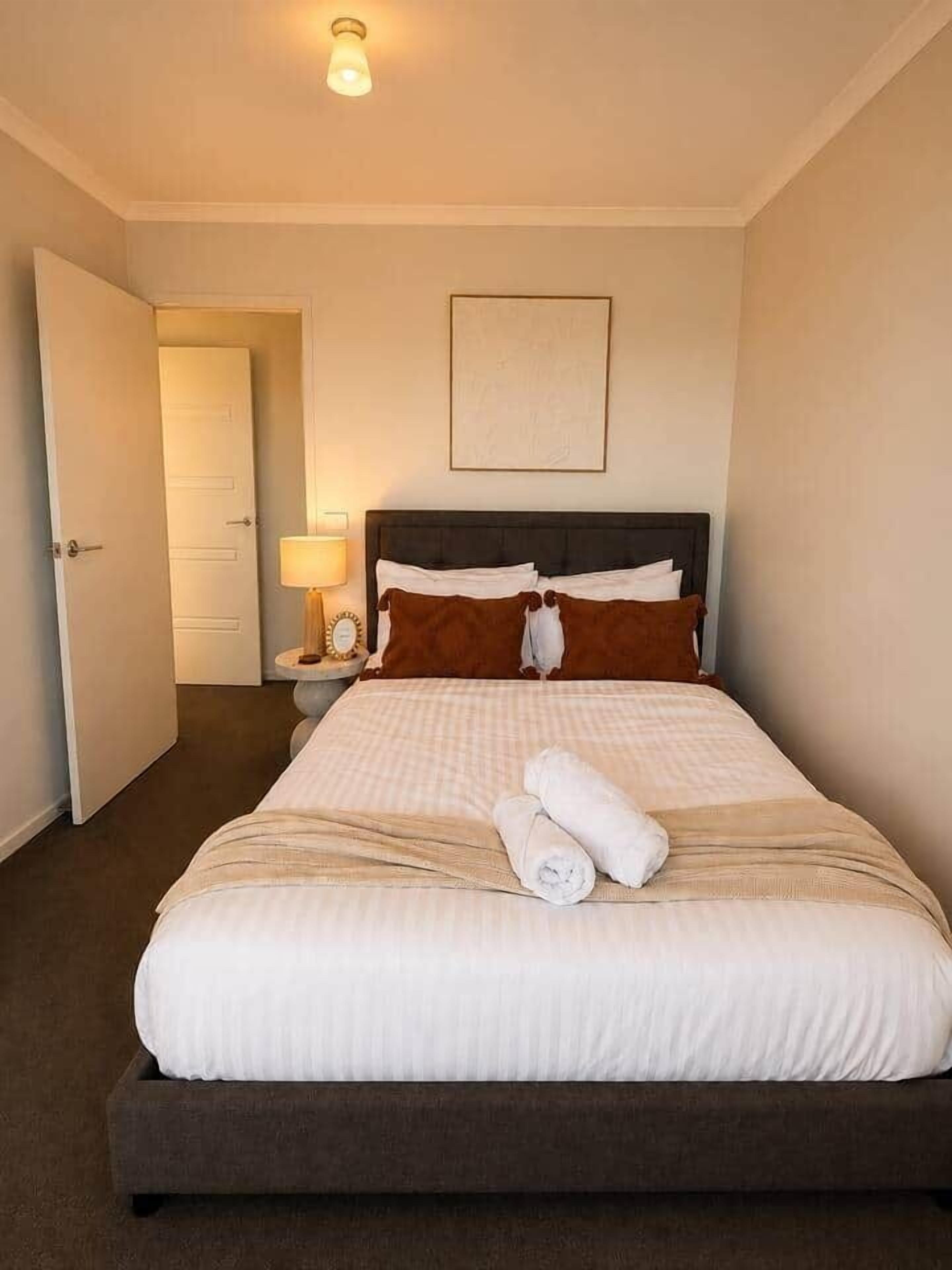 Cozy queen bedroom with warm styling and comfortable fresh linen.