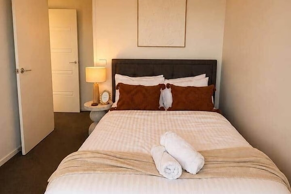 Cozy queen bedroom with warm styling and comfortable fresh linen.
