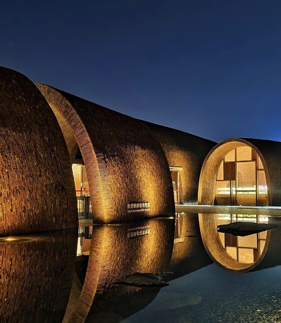 A modern building with cylindrical structures and reflective surfaces.