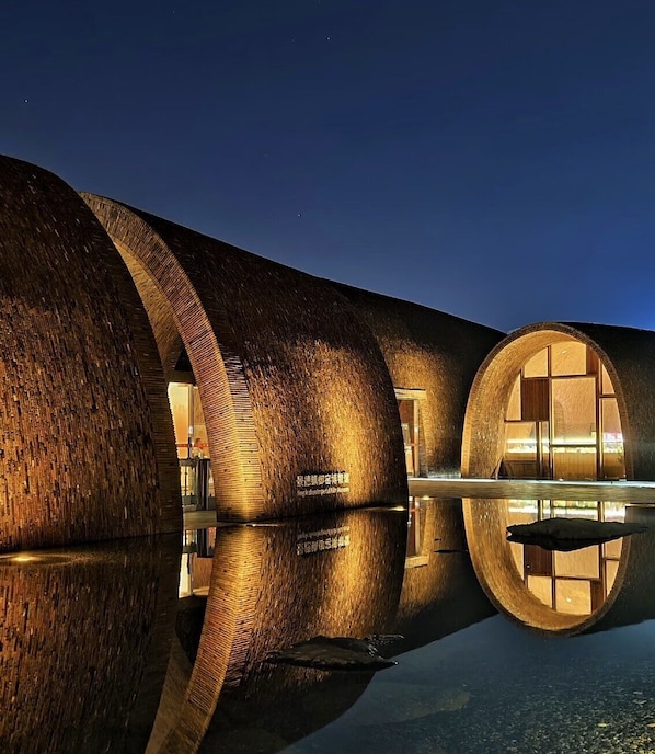 A modern building with cylindrical structures and reflective surfaces.