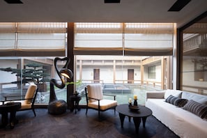 Amplio espacio interior con una disposición de asientos, una fuente de agua y vistas a un edificio tradicional.