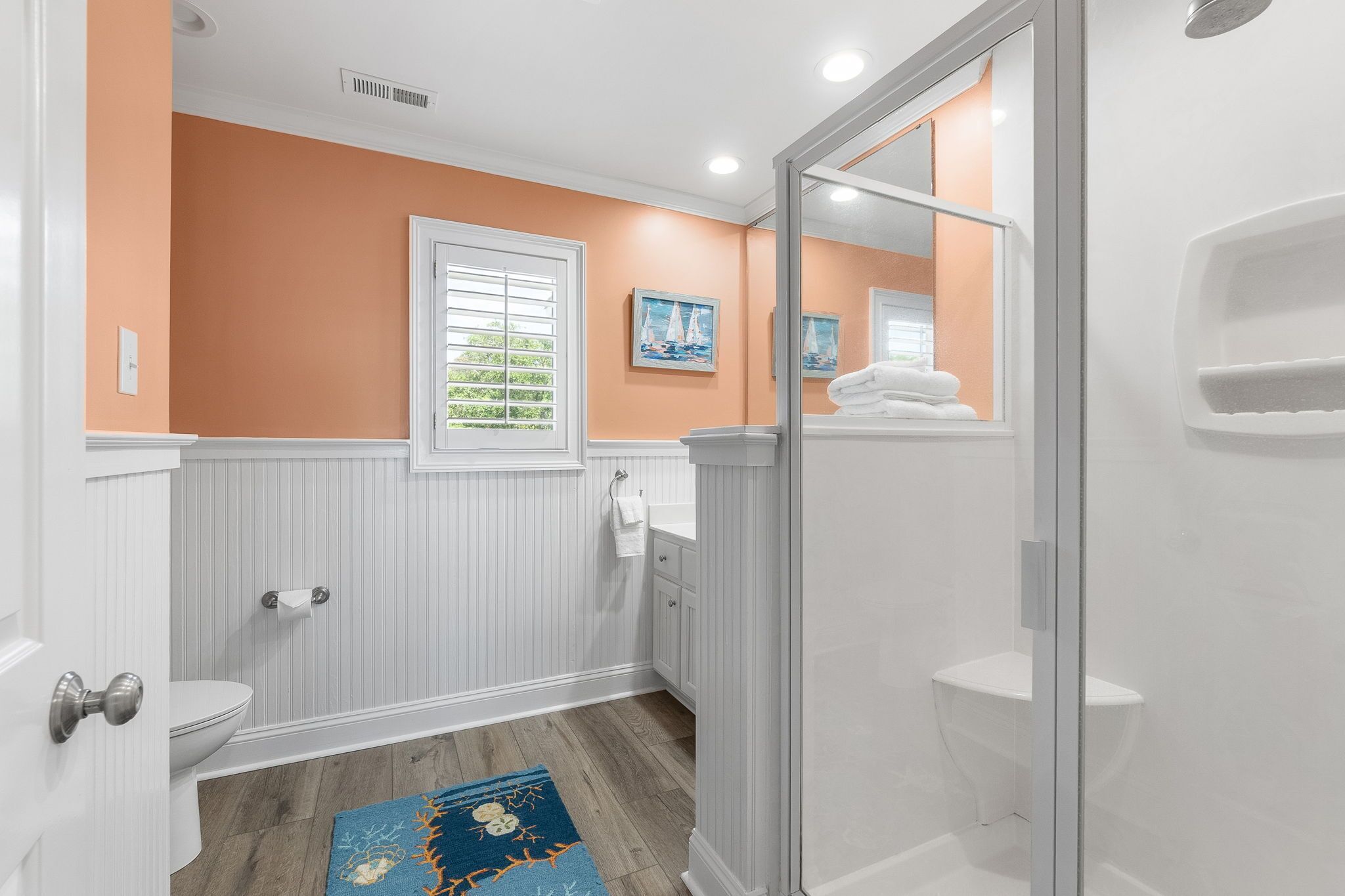 Een badkamer met toilet, wastafel en douche.