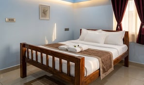 A bedroom with a wooden bed, white bedding, and a small rug.