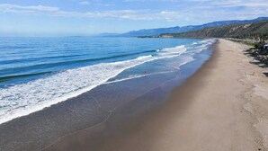 A beach with a clear view of the ocean and distant mountains. - Oceanfront - Island Views - Shoals Beach House (Ventura)