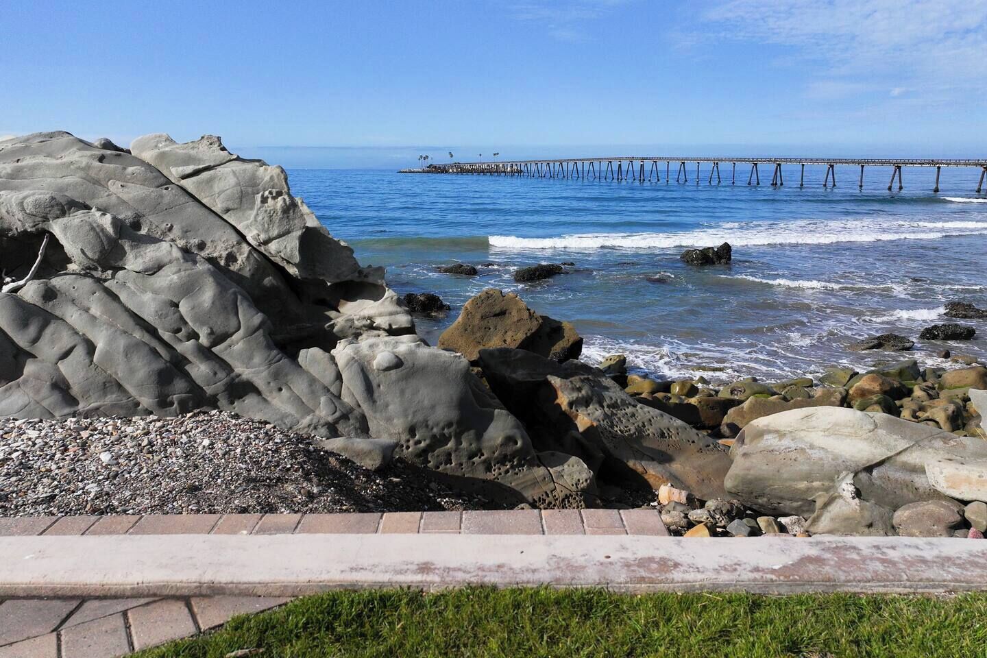 A rocky shoreline with a pier extending into the water.