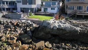 A modern multi-story building with a flat roof, large windows, and a well-maintained lawn. - Oceanfront - Island Views - Shoals Beach House (Ventura)