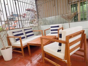 A wooden outdoor seating area with a bench and a table, surrounded by potted plants. - 3BR House, 4 Baths in Hanoi Old Quarter - Washer/Dryer & Kitchen - Zephyr (Hà Nội)