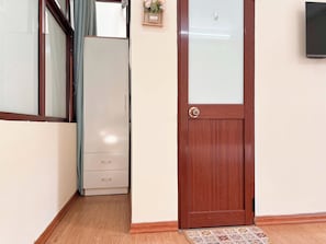 A hallway with a wooden door, a white wardrobe, and a small plant on the wall. - 3BR House, 4 Baths in Hanoi Old Quarter - Washer/Dryer & Kitchen - Zephyr (Hà Nội)