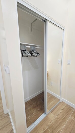 A room with a sliding closet door, a white wall, and a tiled floor. - Brand-New Modern 3BR/3BA Private ADU • A/C • High Ceilings • Canoga Park (Los Angeles)
