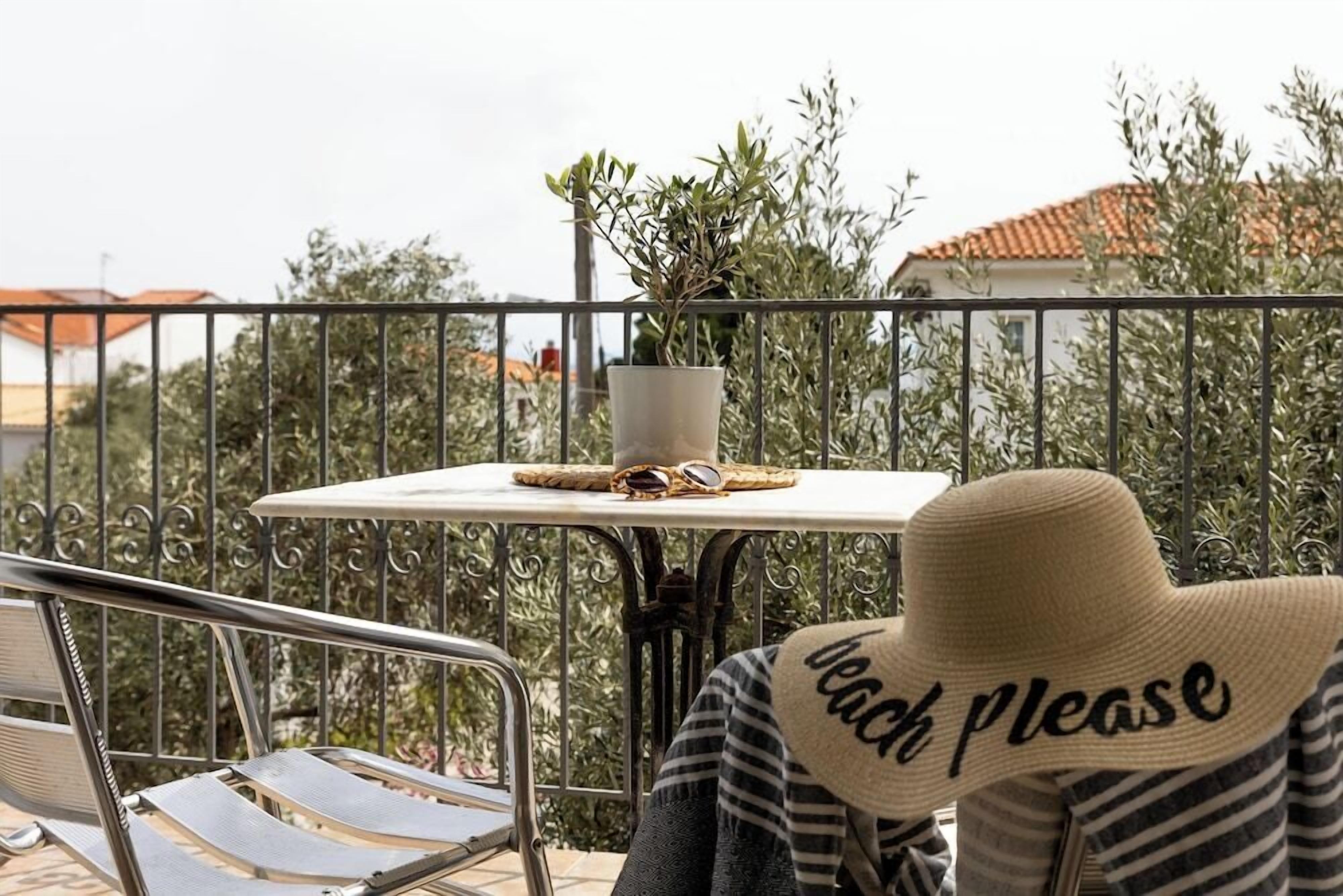 A balcony with a table, a potted plant, and a chair.