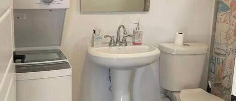 Un baño pequeño con lavabo blanco, inodoro y lavadora.
