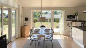 A modern kitchen with a dining area, large windows, and a view of the outdoors. - Gorgeous home in Rudkøbing with sauna (Rudkøbing)