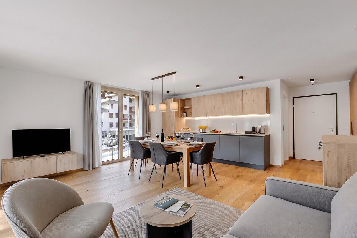 A modern apartment with a dining area, kitchen, and living space.