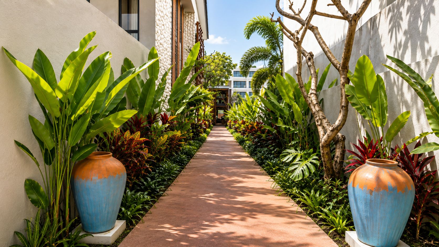 A pathway flanked by large planters and a building with a textured wall.