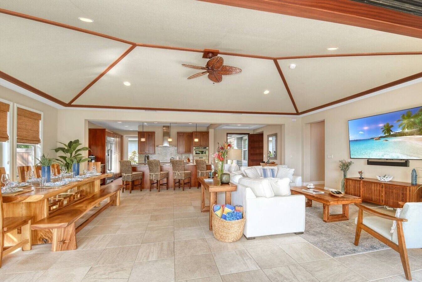A spacious living area with a dining table, chairs, a sofa, and a TV.