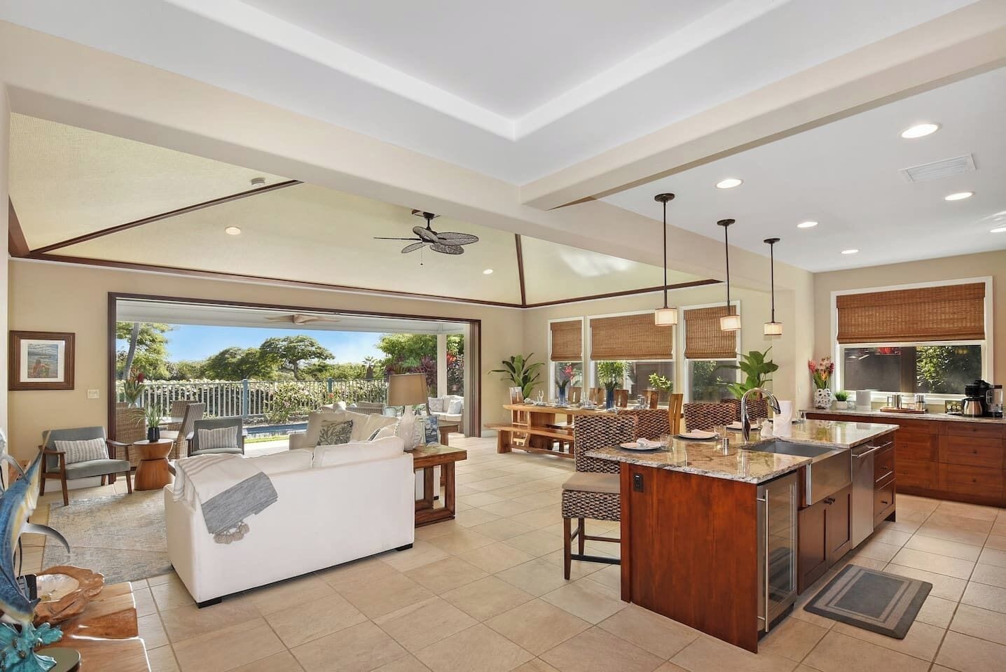A spacious living area with a large sofa, dining table, and a kitchen with a central island.
