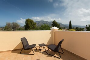 A terrace with two chairs and a small table, overlooking a mountainous landscape. - Villas Lomas de Marbella (Marbella)