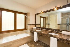 Un baño con bañera, dos lavamanos, un espejo grande y una ducha.