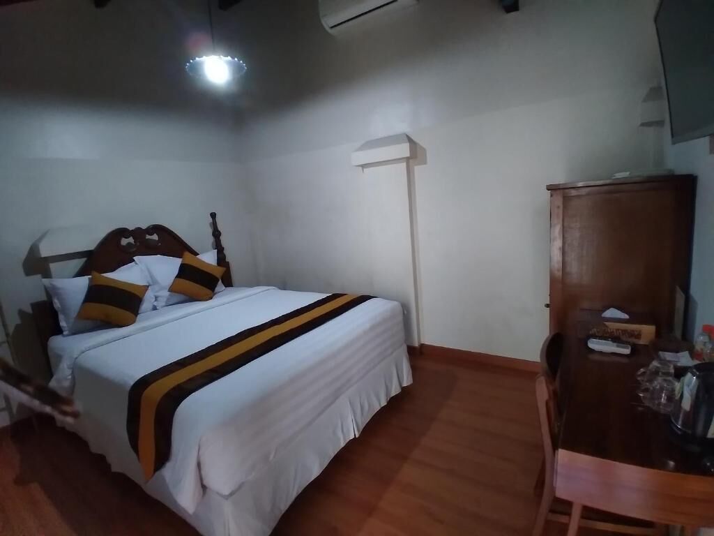 A bedroom with a bed, a bedside table, a wardrobe, and a ceiling light.