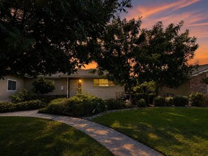A residential house with a front yard, a pathway leading to the entrance, and a tree providing shade. - Luxury Casa Sequoia (Dinuba)