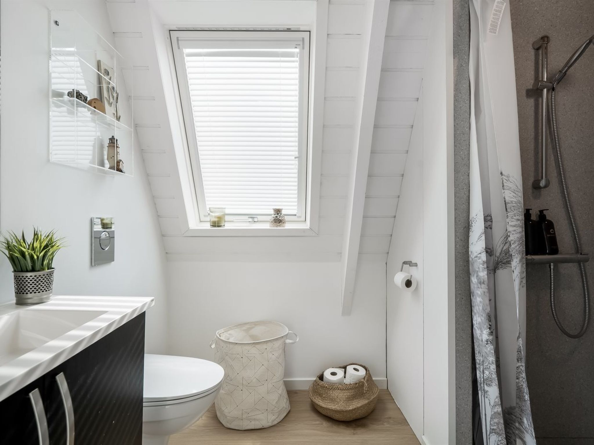 A small, modern bathroom with a skylight, a shower, and a toilet.