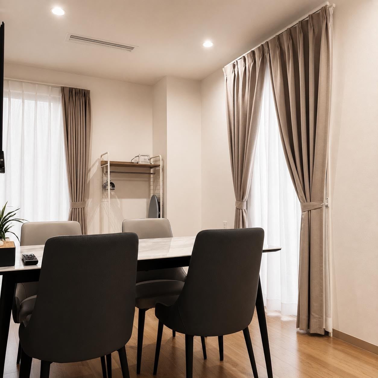 A modern dining area with a table, chairs, and a hanging rack.