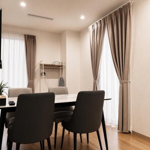 Un comedor moderno con una mesa, sillas y un perchero.