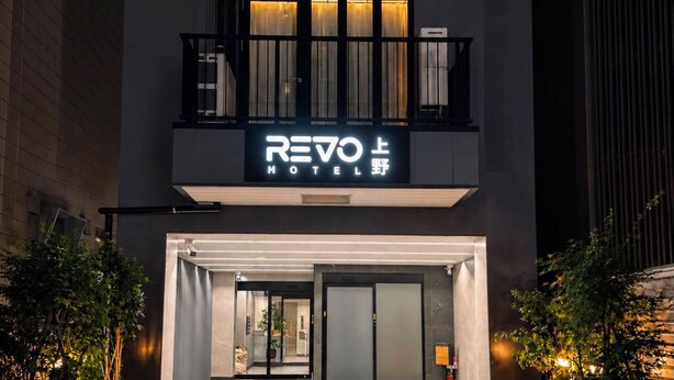 Una entrada de hotel moderna con un letrero que dice 'REVO HOTEL'.