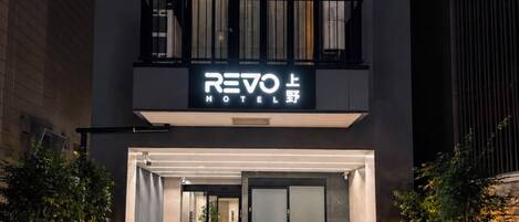 Una entrada de hotel moderna con un letrero que dice 'REVO HOTEL'.