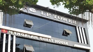 A building with a sign reading 'I.P. Tow EE' and 'Mangalam Guest House' indicating it is a guest house.