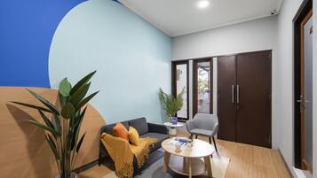 A modern living room with a sofa, a coffee table, and a potted plant.