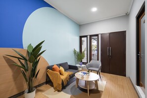 A modern living room with a sofa, a coffee table, and a potted plant.