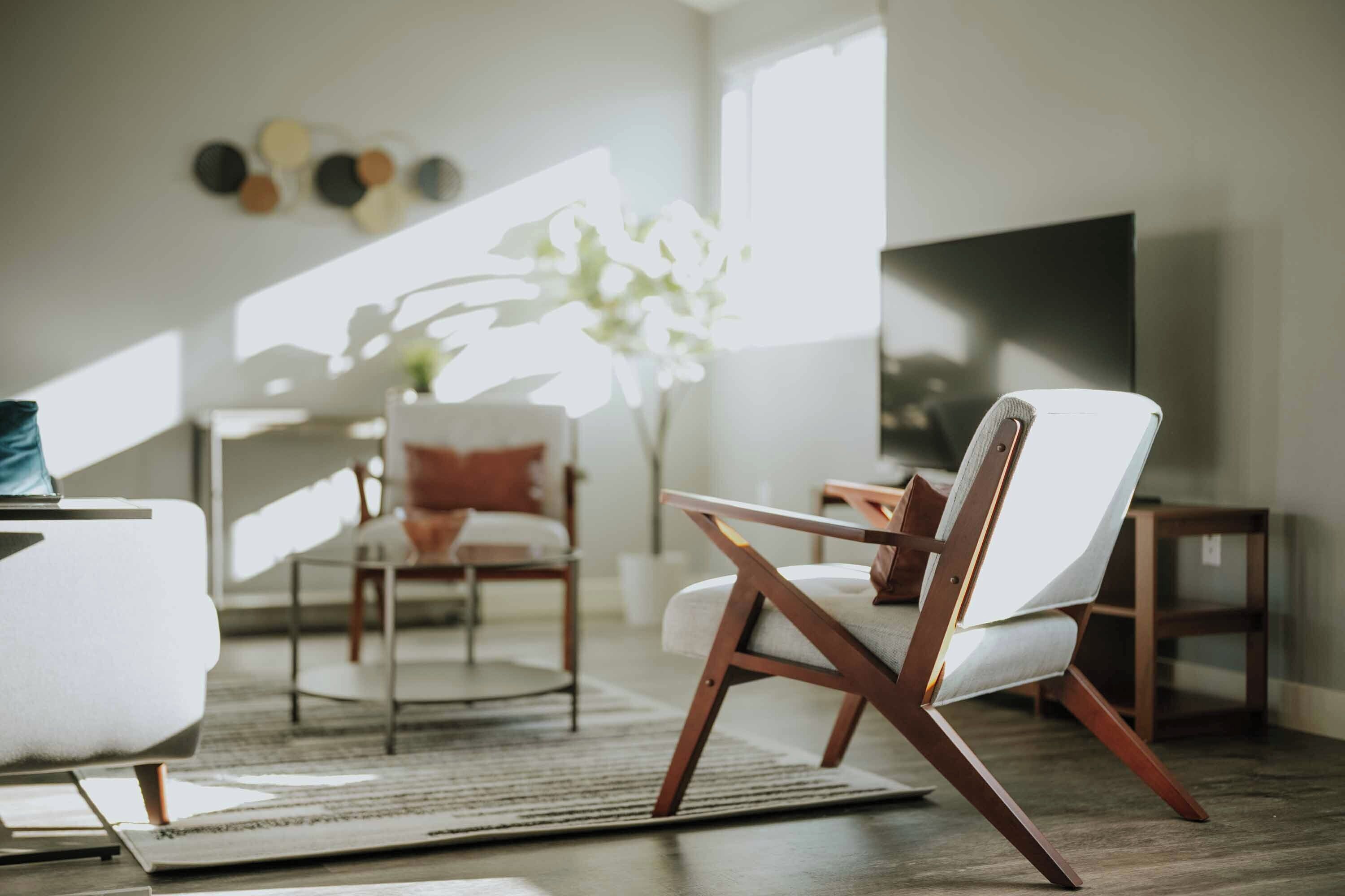 A modern living room with a sofa, a chair, a coffee table, and a TV.
