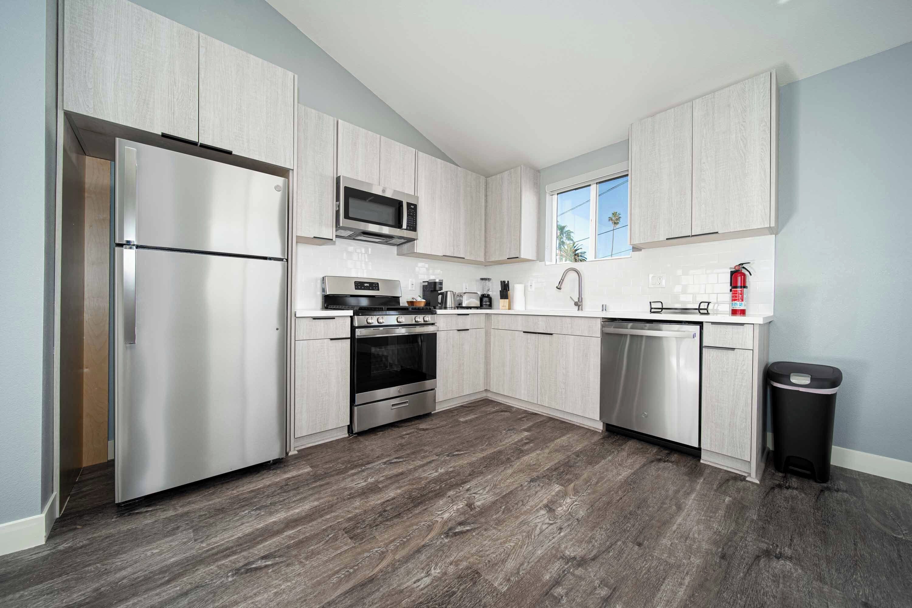 A modern kitchen with stainless steel appliances, a microwave, a stove, and a dishwasher.