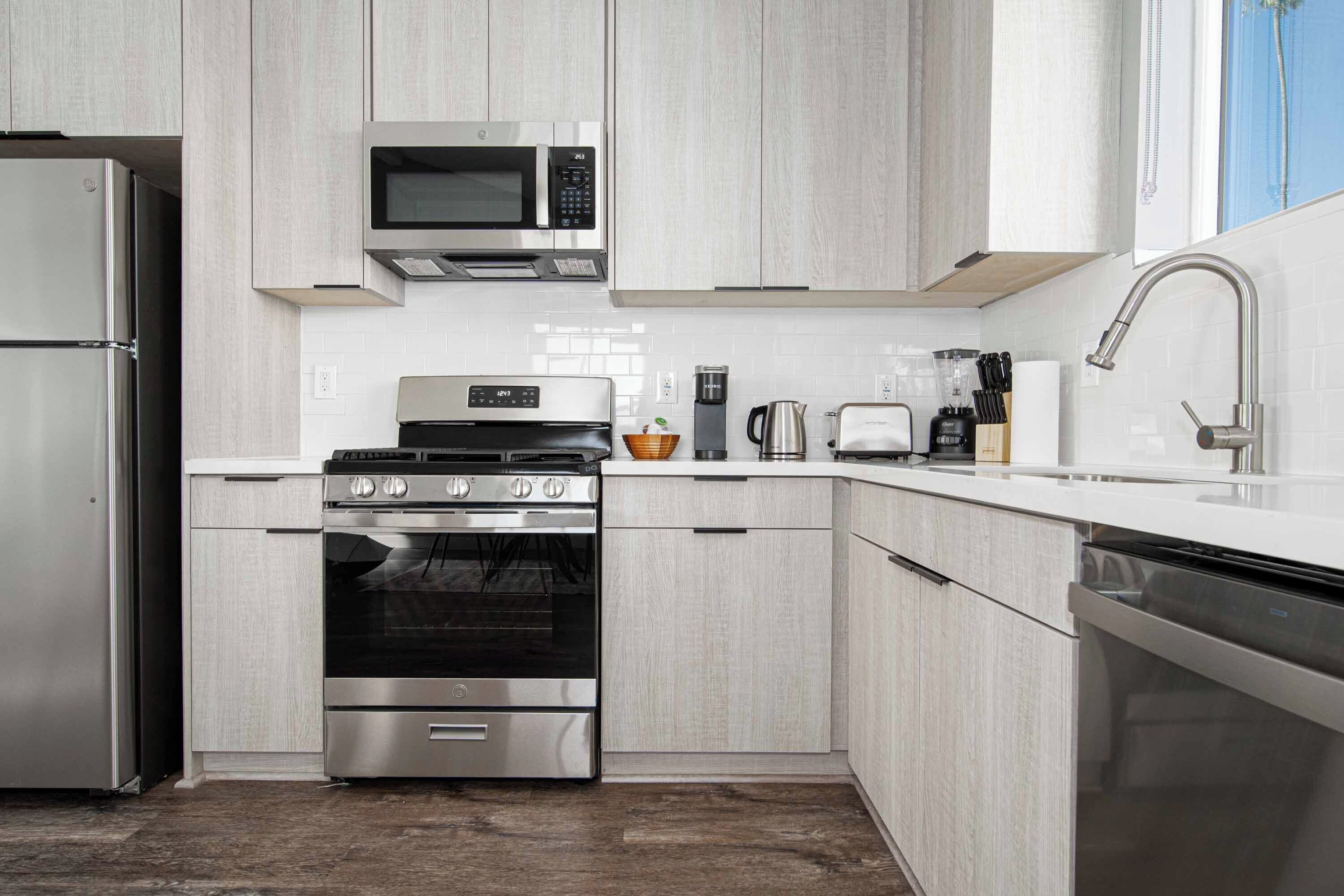 A modern kitchen with stainless steel appliances, a built-in microwave, and a coffee maker.