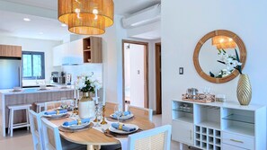 A modern kitchen with a dining area, a large mirror, and a decorative vase. - Peaceful Pool View Walk to Fun Beach Dine Shop (Punta Cana)